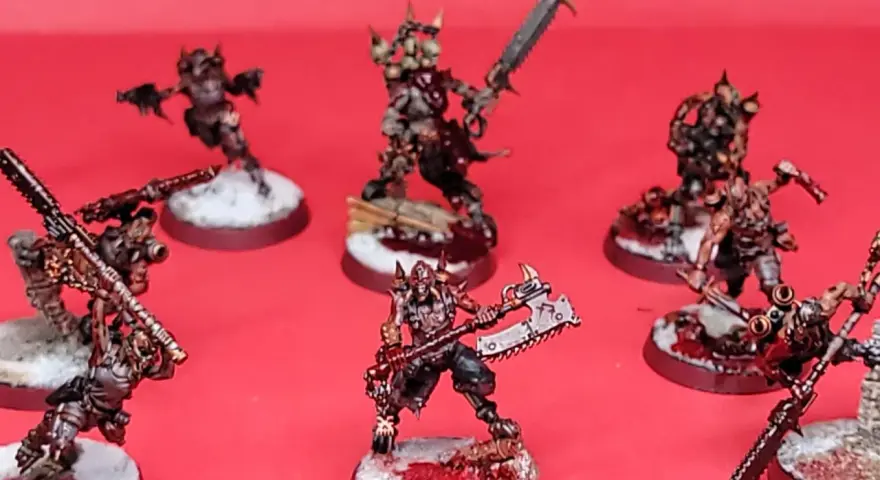 Un gruppo di guerrieri minacciosi, pronti per i giochi miniature. Le loro armature sono dettagliate e le armi affilate, con basi innevate e macchiate di sangue.