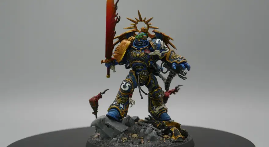 Roboute Guilliman, Primarca degli Ultramarines, brandisce la spada ardente su un campo di battaglia disseminato di teschi.