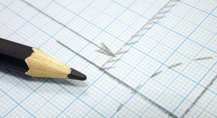 Matita nera su carta millimetrata con linee e frecce disegnate, utile per calcolare la proporzione per trovare la scala di un disegno.