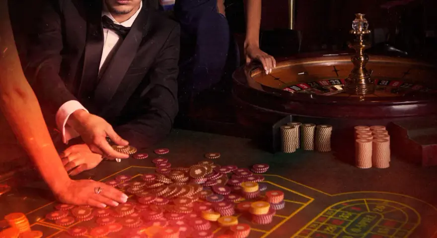 Mani che giocano a las vegas gioco carte, con fiches e roulette in un'atmosfera da casinò.