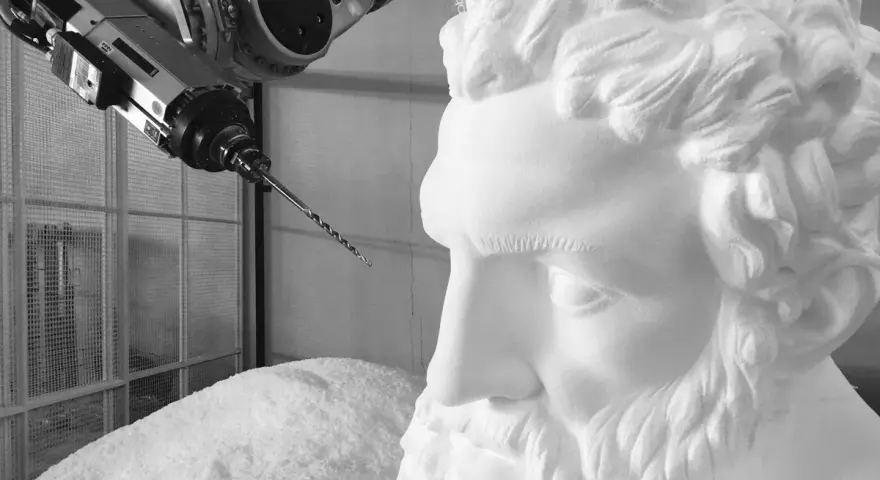 Un braccio robotico con una punta da trapano si avvicina a un busto di polistirolo, suggerendo un metodo innovativo per come sciogliere il polistirolo.