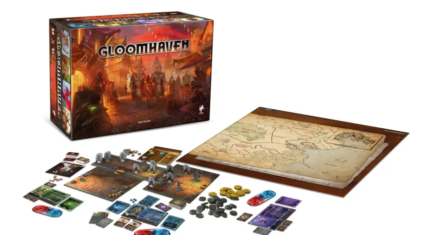 La scatola di Gloomhaven, la mappa del mondo e i componenti del gioco pronti per una nuova avventura. Una recensione di questo epico gioco da tavolo.