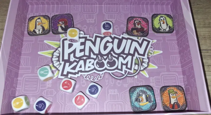 Il gioco di carte Penguin Kaboom! con dadi e pedine pinguino. Preparati per un'esplosione di divertimento!