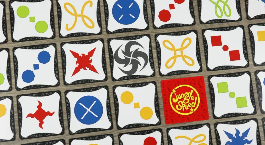Carte di Jungle Speed con simboli colorati. Le regole del gioco sono semplici: trova le coppie di simboli identici per vincere.