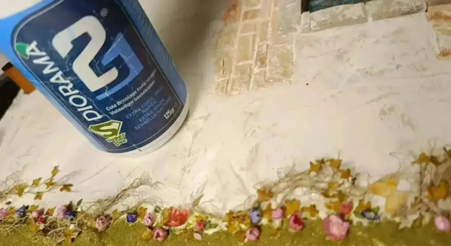 Colla vinilica DIORAMA usata per creare un paesaggio in miniatura con sabbia e fiori.