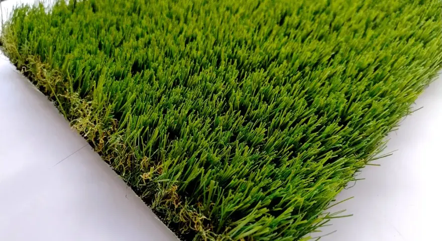Un campione di erba sintetica, verde brillante e folta, mostra come fare l'erba finta per un giardino perfetto.