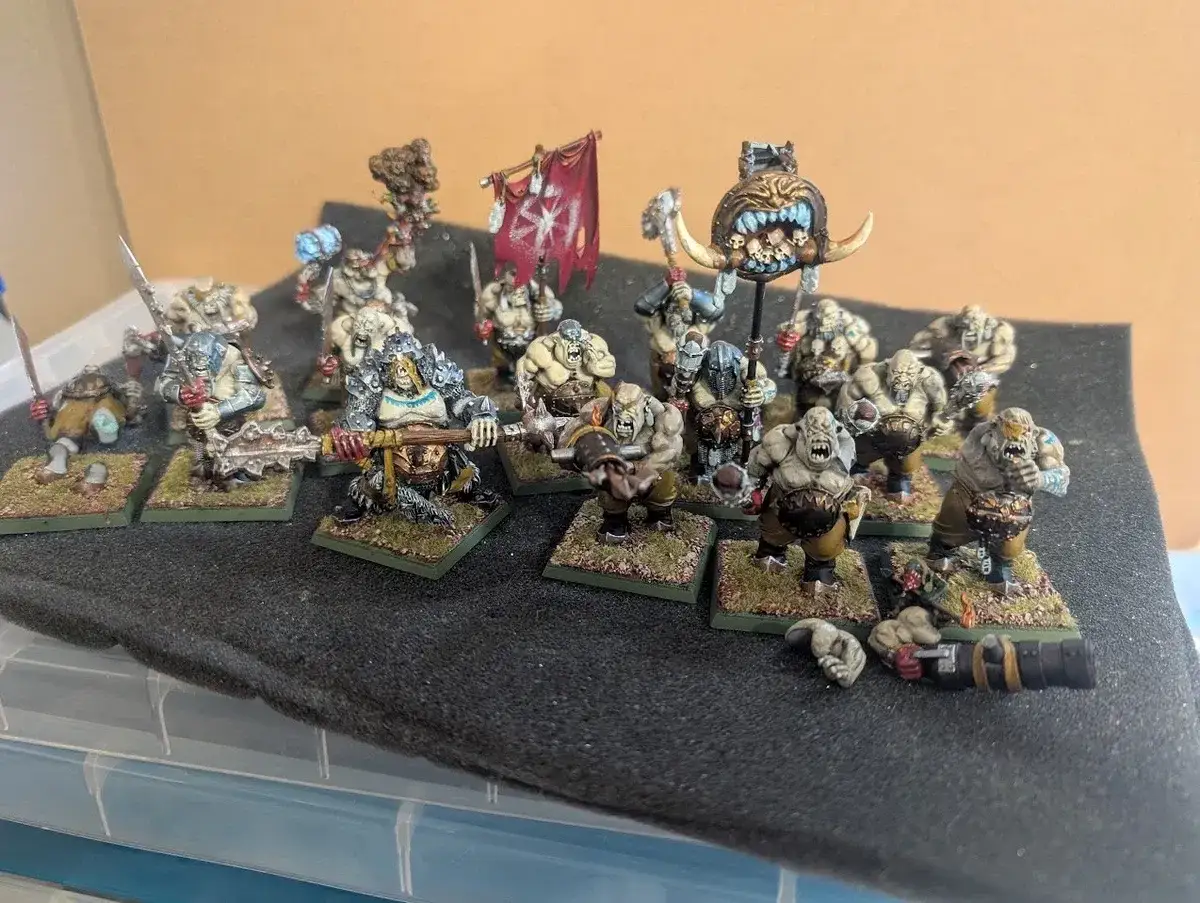 Un esercito di orchi pronti per il gioco da tavola guerra. Figure dettagliate con armi e stendardi, in posa minacciosa.