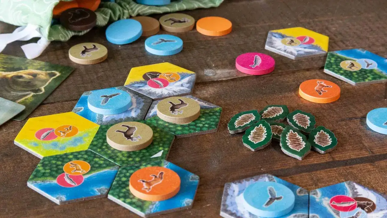 Tasselli esagonali con animali e risorse per parks gioco da tavolo. Pezzi rotondi colorati e sacchetto in tessuto.