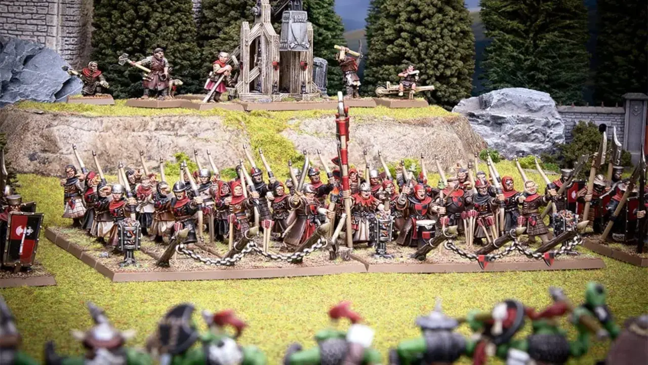 Esercito di Warhammer Fantasy pronto alla battaglia, con soldati in armatura e balestrieri schierati.