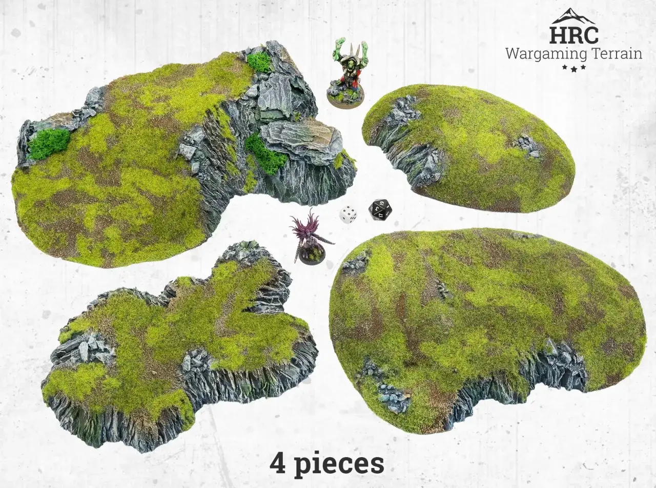 Wargaming terrain pieces with mossy rocks, two miniatures, and dice.