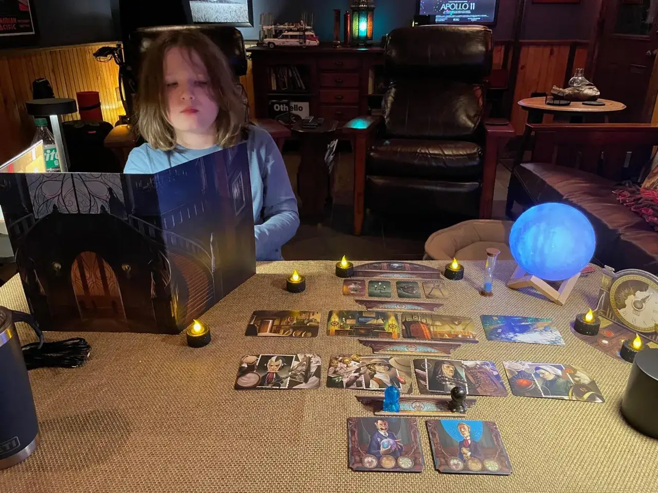 Bambino gioca a Mysterium. La recensione del gioco da tavolo è positiva, con un'atmosfera suggestiva e carte illustrate.