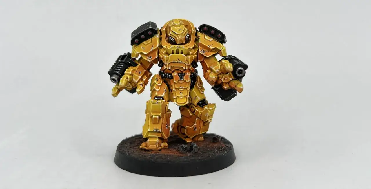 Miniatura di un guerriero corazzato giallo, pronto al combattimento, con pistole in entrambe le mani. Un vero esempio degli Imperial Fists.