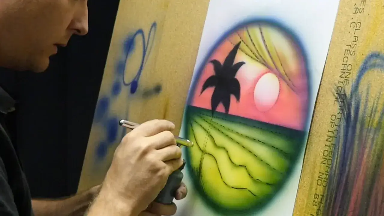 Artista crea un paesaggio tropicale con aerografo, mostrando come usare aerografo per sfumature e dettagli.