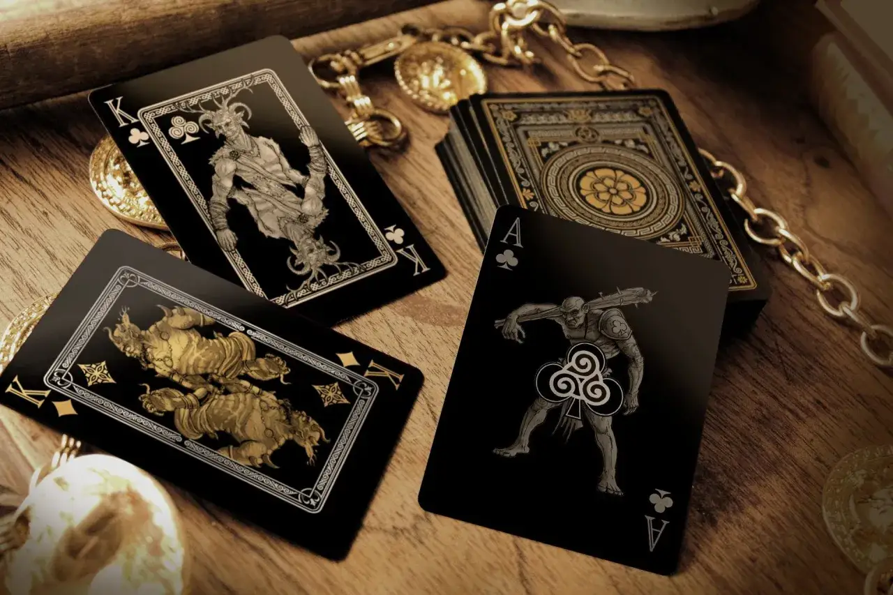 Carte da gioco nere con illustrazioni di creature fantastiche, tra cui un re demoniaco e un guerriero, che evocano i tiranni dell'underdark.