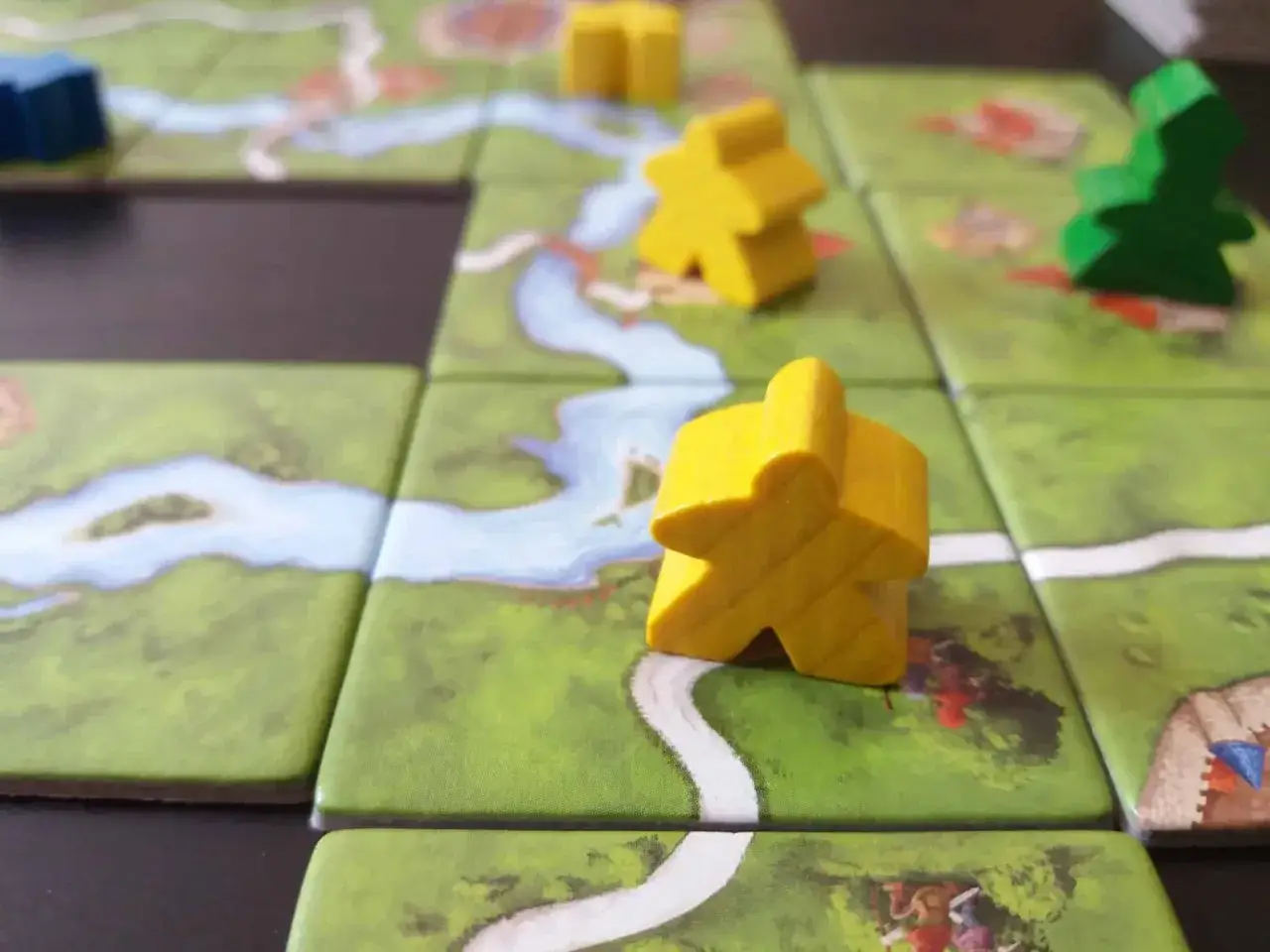Pedine gialle e verdi su un tabellone di gioco con fiume e strade. Perfetto per i giochi da fare in due, un'avventura strategica ti aspetta!
