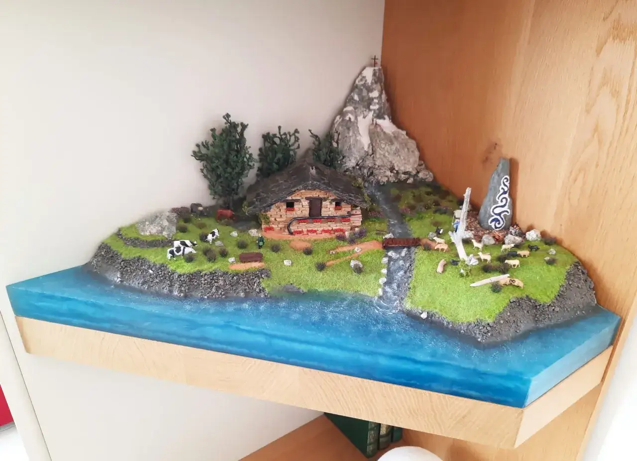 Un diorama cos'è? Una scena alpina in miniatura con casetta, montagne, animali e un fiume cristallino.