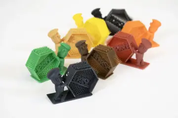 Piccoli omini colorati sorreggono oggetti esagonali con punte. Attenzione, respirare resina fa male!