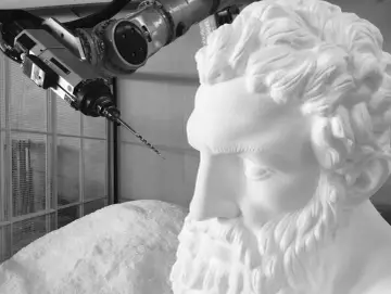Un braccio robotico con una punta da trapano si avvicina a un busto di polistirolo, suggerendo un metodo innovativo per come sciogliere il polistirolo.