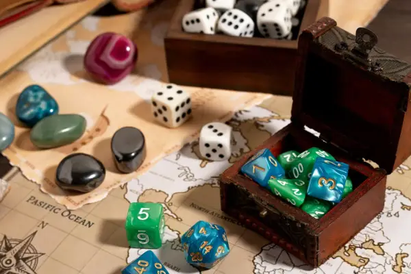 Dadi colorati e pietre preziose su una mappa antica, pronti per i migliori giochi da tavolo.