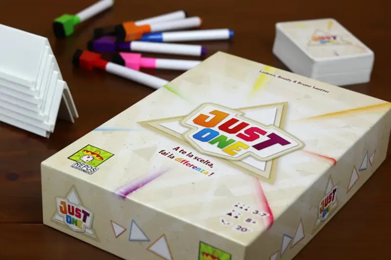 Scatola del gioco da tavolo "Just One" con pennarelli colorati e supporti bianchi. Un gioco per tutti!